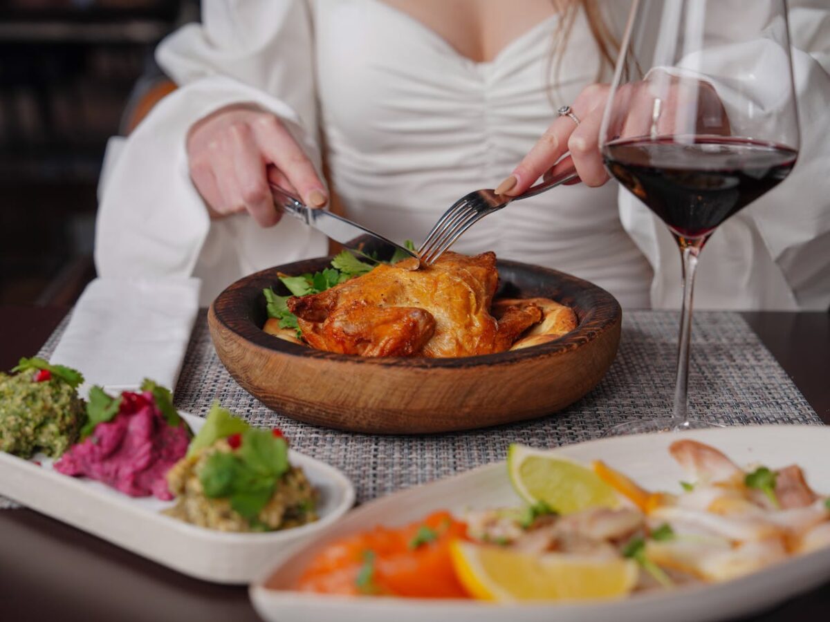 A stylish dinner setting with roast chicken and red wine, perfect for a romantic evening.