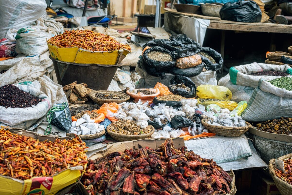 Vibrant display of diverse spices and herbs at an outdoor market stall.
