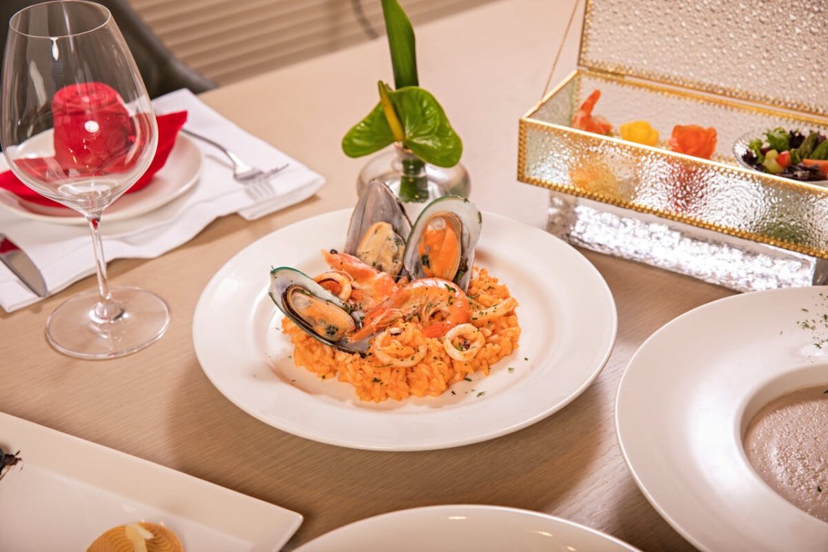 Delightful seafood risotto served in an elegant dining setting with wine.