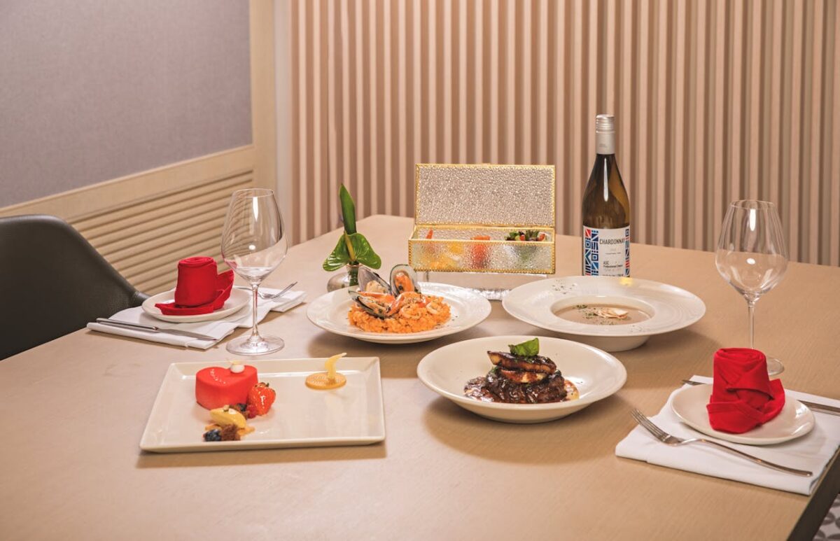 Luxurious dining setup with gourmet seafood, wine, and desserts on an elegantly dressed table.